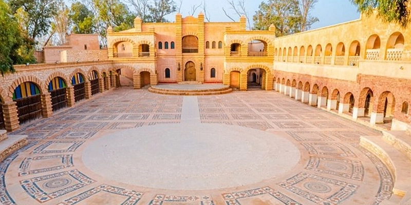 Vue sur la grande cour circulaire de la Agadir Médina Polizzi, avec ses arcades en pierre, mosaïques traditionnelles et architecture inspirée des médinas marocaines.